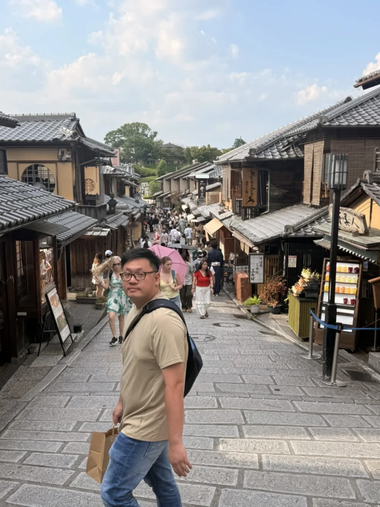 7-Day Osaka, Kyoto and Kobe Itinerary: Food, Shopping and Summer Sights 26 Man walking along a traditional stone-paved street lined with wooden machiya buildings in Kyoto’s Gion district.