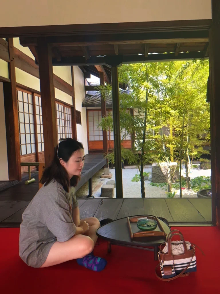 7-Day Osaka, Kyoto and Kobe Itinerary: Food, Shopping and Summer Sights 28 Woman enjoying green tea beside a bamboo courtyard at a traditional temple in Kyoto’s Gion district.