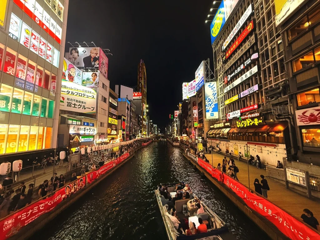 7-Day Osaka, Kyoto and Kobe Itinerary: Food, Shopping and Summer Sights 15 Dotonbori Canal at night with illuminated restaurants, crowded riverside walkways and a sightseeing boat in Osaka.