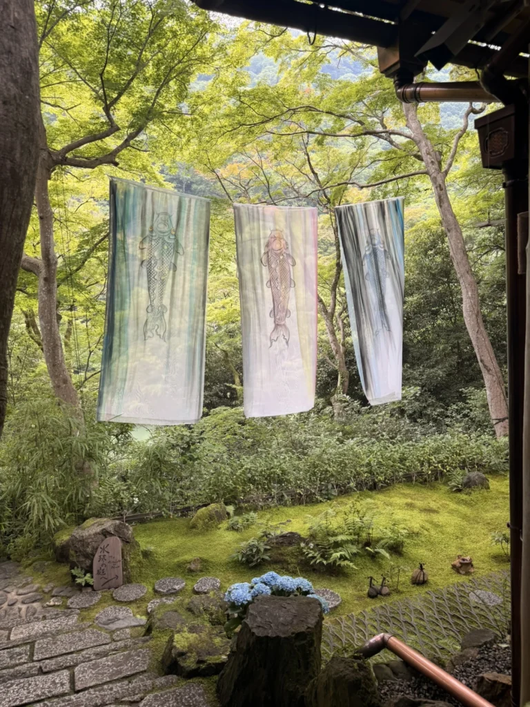 Hand-dyed silk textile art displayed in the garden of Arashiyama Yusai-tei