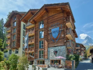 Hotel Firefly in Zermatt with traditional wooden chalet architecture and the Matterhorn in the background