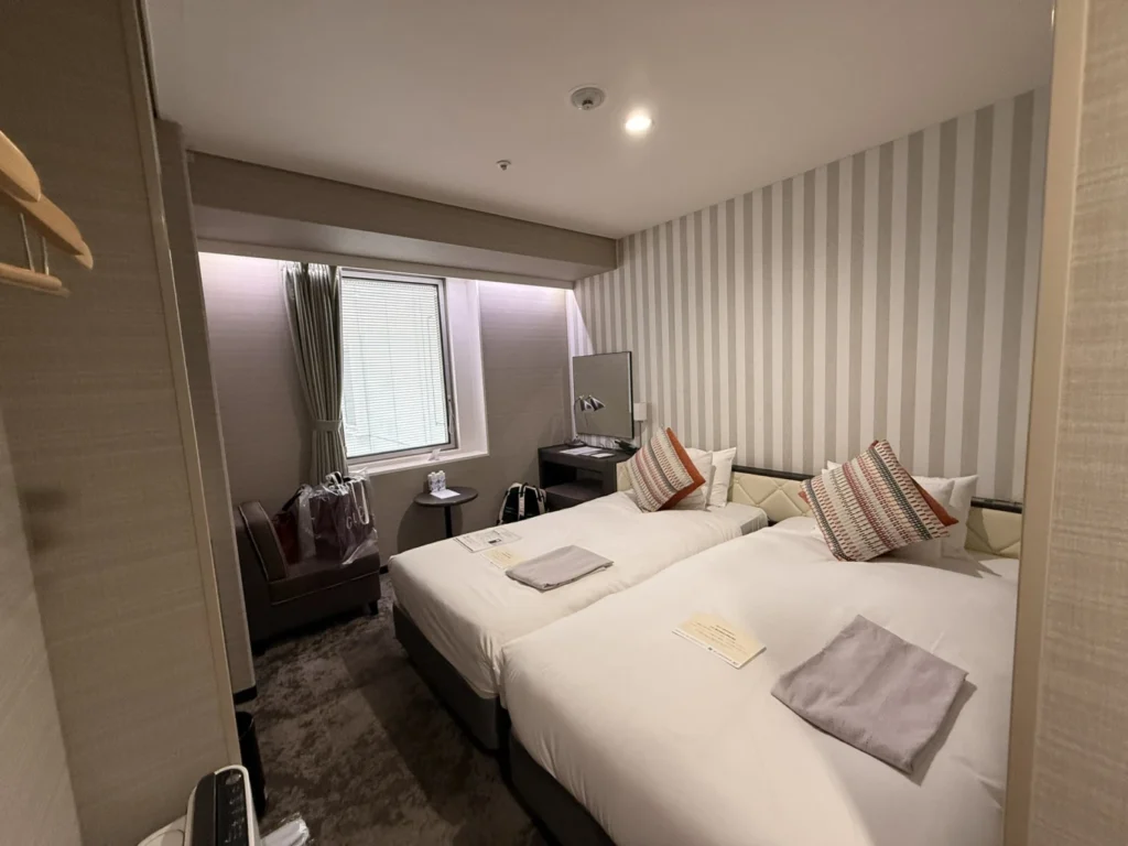 7-Day Osaka, Kyoto and Kobe Itinerary: Food, Shopping and Summer Sights 9 Twin room at Hotel Granvia Osaka with two single beds, a small seating area and a window near Osaka Station.