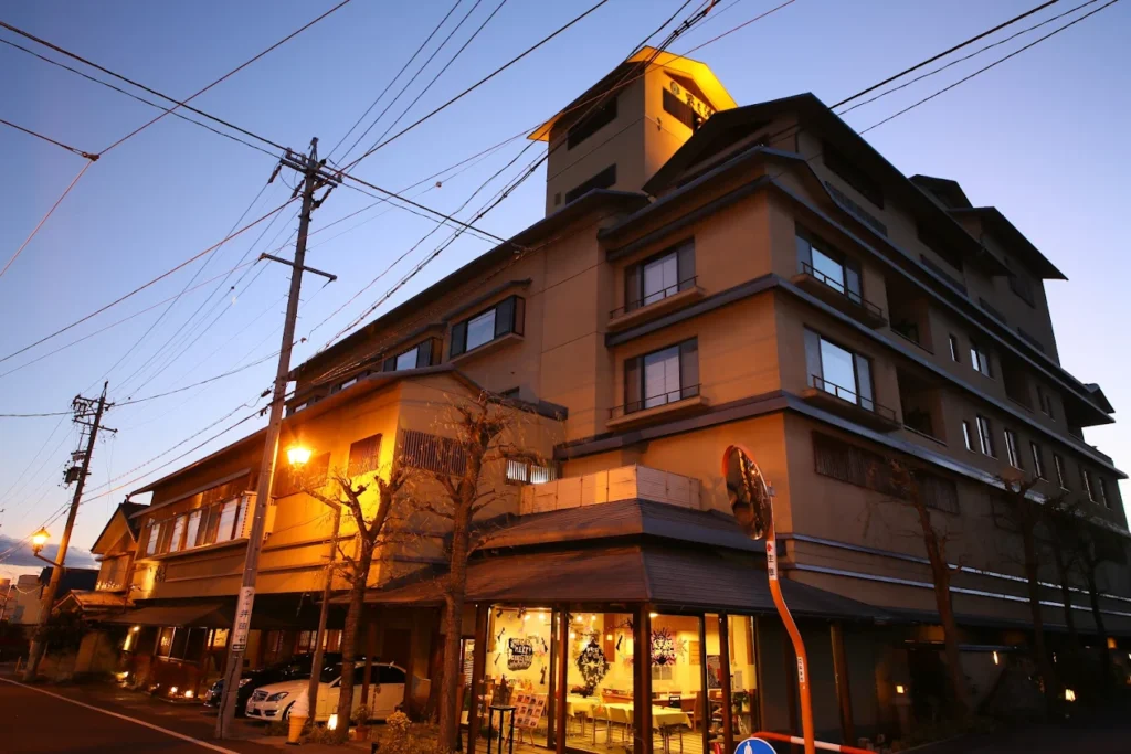 Exterior of Hotel Tamanoyu at dusk, a traditional ryokan in Asama Onsen featuring classic Japanese architecture near Matsumoto.