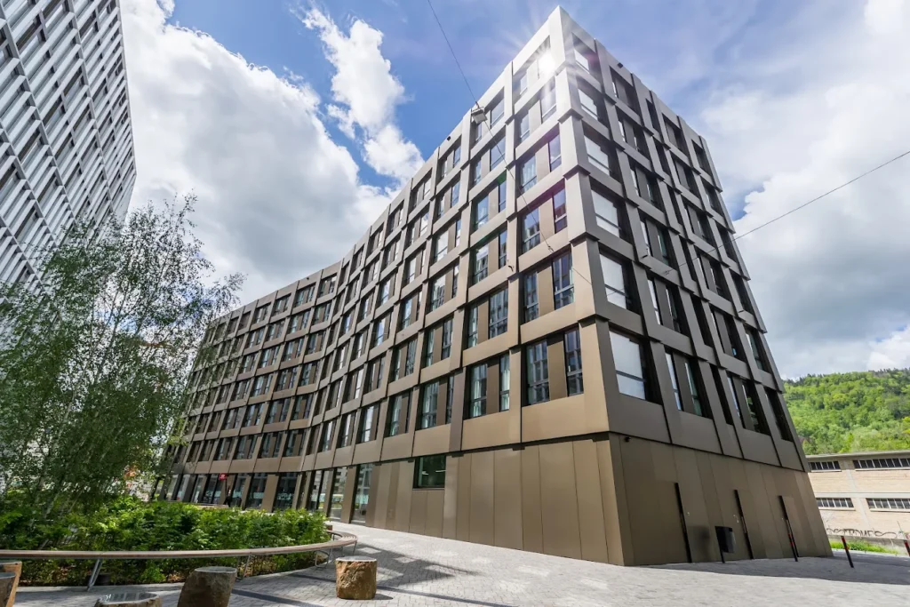 Exterior view of MEININGER Hotel Zürich Greencity, a modern budget-friendly hotel in Zurich with spacious family rooms and contemporary architecture.
