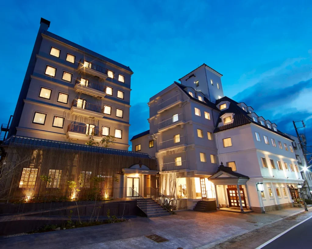 Exterior of Matsumoto Hotel Kagetsu illuminated at dusk, showcasing its elegant European-inspired architecture in central Matsumoto, Japan.
