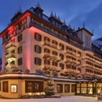 Mont Cervin Palace hotel illuminated at dusk in snowy Zermatt, Switzerland