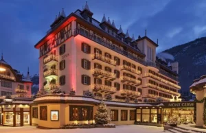 Mont Cervin Palace hotel illuminated at dusk in snowy Zermatt, Switzerland