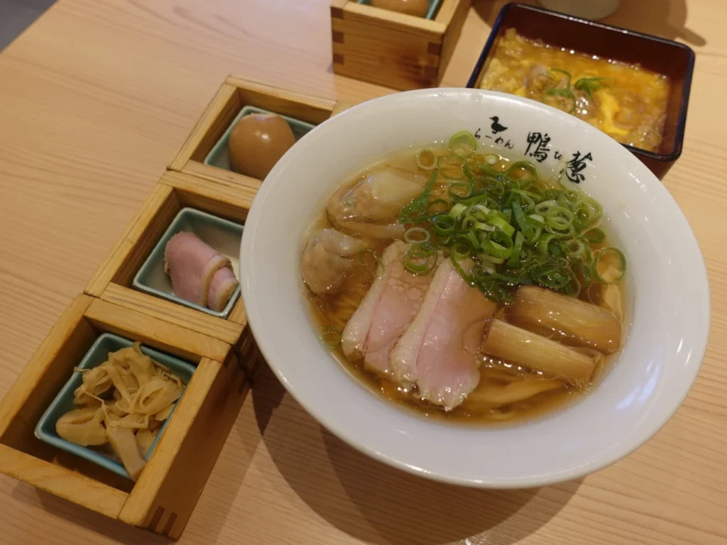 Signature duck ramen with spring onions, wontons and premium toppings at Ramen Kamo to Negi Osaka