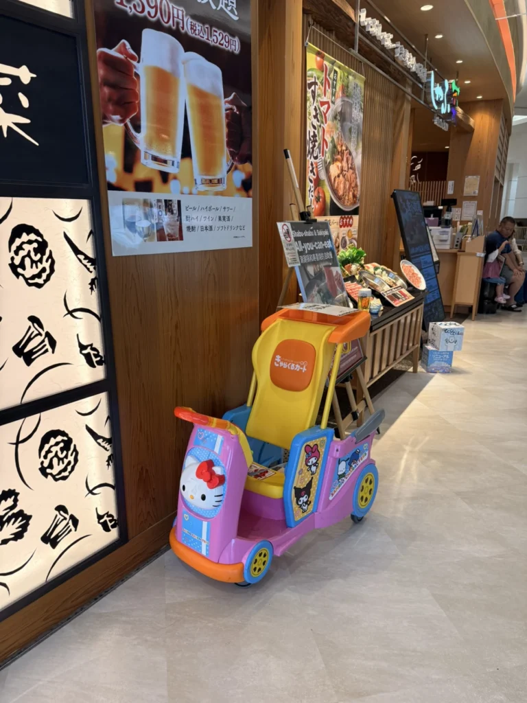 Entrance to Shabu Sai at AEON Mall Kobe Kita near Kobe-Sanda Premium Outlets, featuring the restaurant's family-friendly atmosphere and Hello Kitty children's cart.