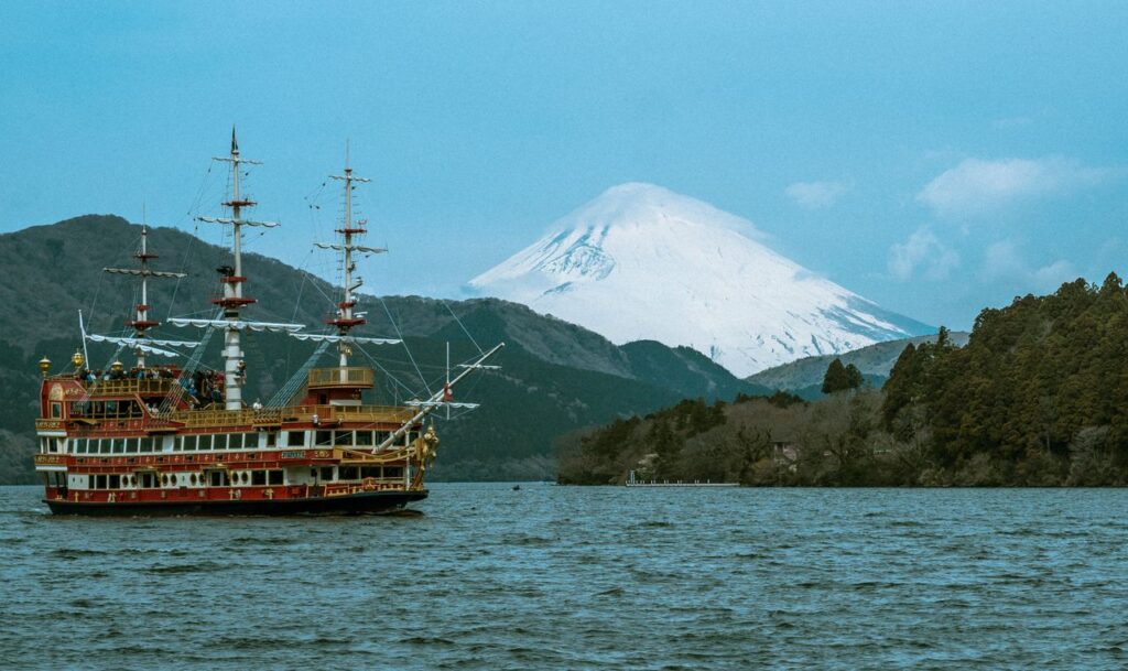 Hakone sightseeing pirate ship cruising across Lake Ashi with snow-capped Mount Fuji in the background on a clear day.