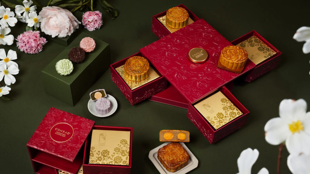 Conrad Singapore Marina Bay Golden Peony baked and snowskin mooncakes displayed in red luxury gift boxes for Mid-Autumn Festival 2026