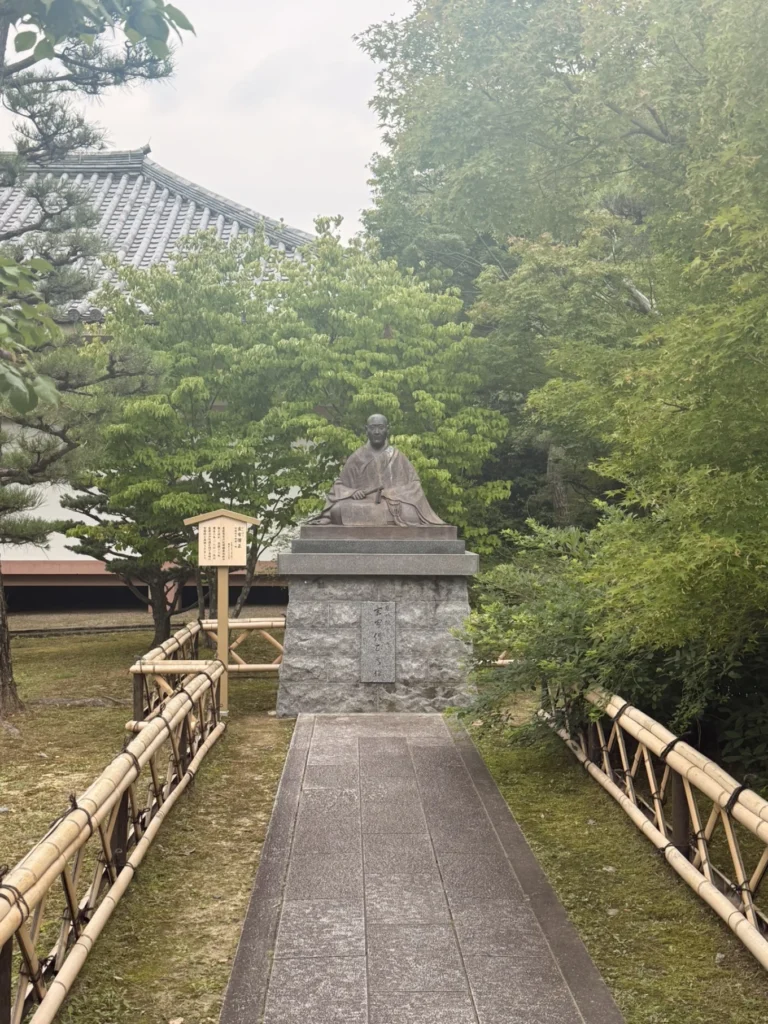 Buddhist monk statue surrounded by greenery at Chishaku-in Temple Kyoto