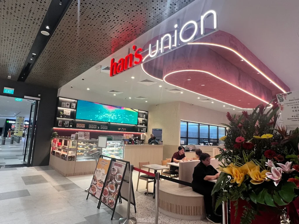 Lentor Modern Food Guide: 17 Best Places To Eat Near Lentor MRT 19 Han’s Union restaurant storefront at Lentor Modern, featuring illuminated signage, pastry displays and bright casual seating.