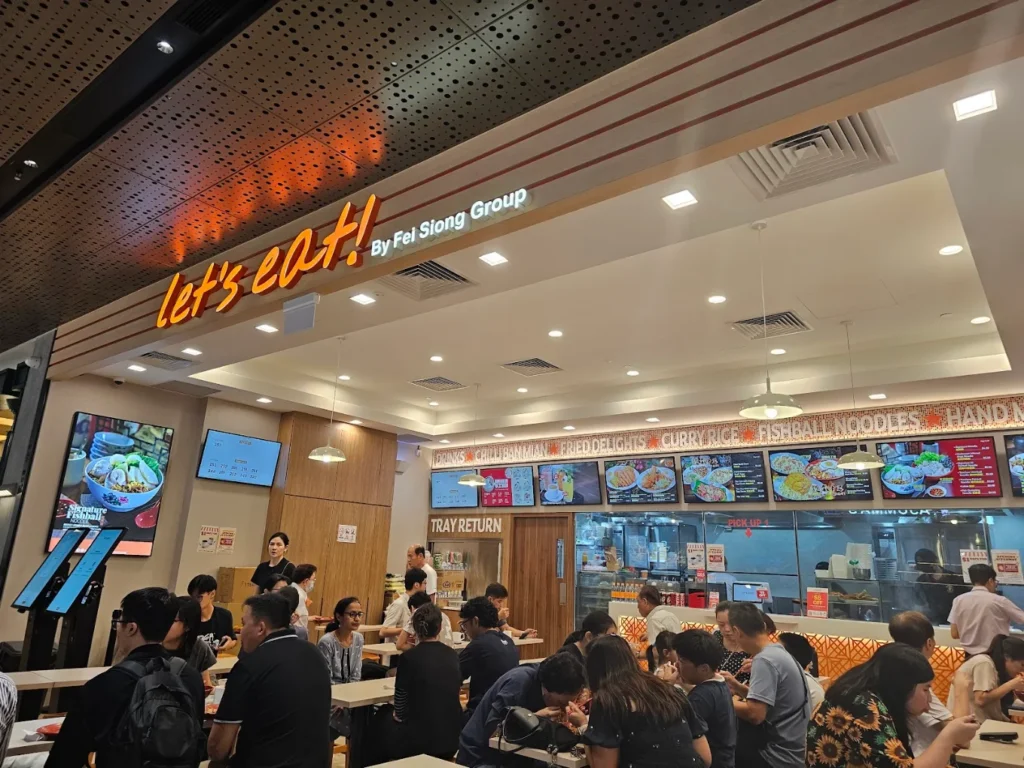 Lentor Modern Food Guide: 17 Best Places To Eat Near Lentor MRT 20 Let’s Eat! food court at Lentor Modern, featuring Fei Siong Group signage, digital menus and a busy dining area.
