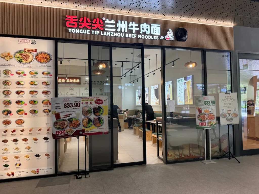 Lentor Modern Food Guide: 17 Best Places To Eat Near Lentor MRT 17 Tongue Tip Lanzhou Beef Noodles restaurant storefront at Lentor Modern, with illuminated signage, menu displays and casual seating inside.